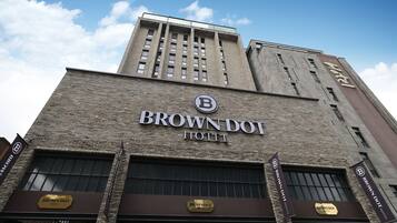 Un bâtiment sur lequel on peut lire l’inscription « BROWN DOT HOTEL » et qui est surmonté d’un logo.