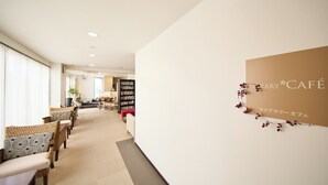 A library and café interior with seating, bookshelves, and a sign reading "LIBRARY*CAFÉ". - HOTEL HOLISTIC RESORT (Taiji)