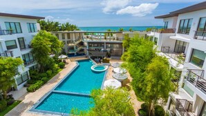 A modern hotel with a central swimming pool, outdoor seating, and a view of the ocean. - Discovery Boracay (Boracay Island)