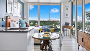 A modern apartment with a balcony, a dining area, and a kitchen.