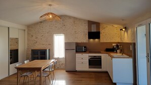 A compact kitchen with a dining area, a built-in microwave, oven, and a small sink.