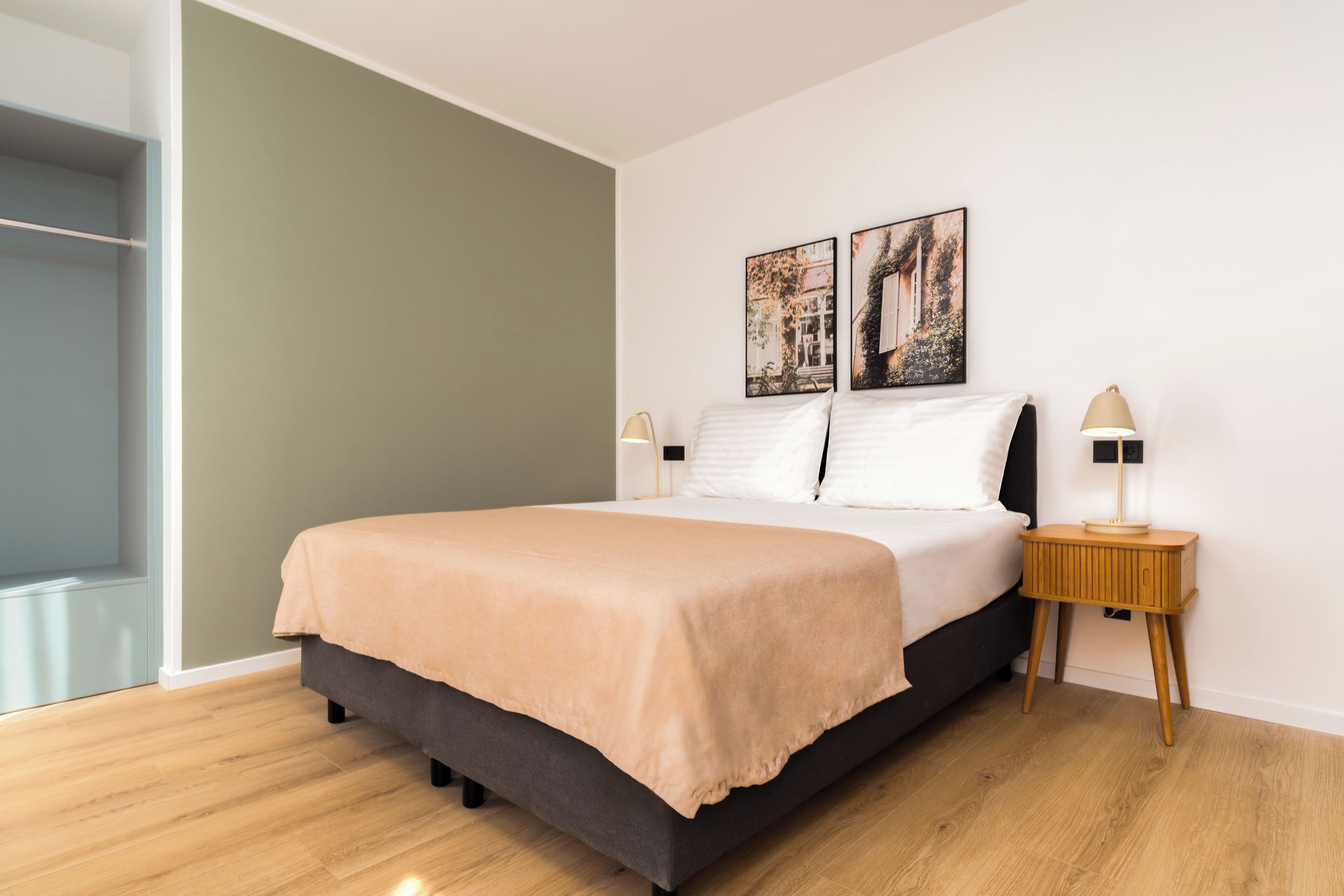 A modern bedroom with a bed, two bedside tables, and a window.