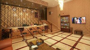 A lobby with a bar area, a staircase, and a television screen. - Ligang Hotel (Chongqing)