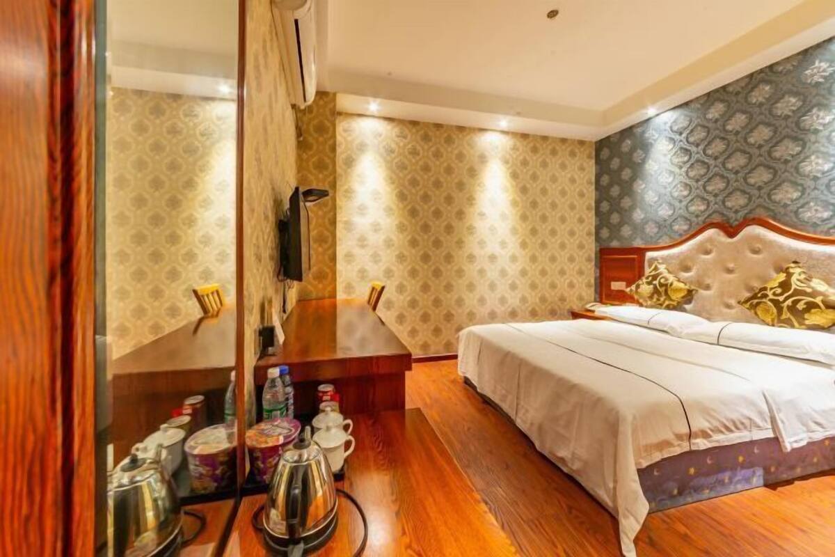 Een hotelkamer met een bed, een houten bureau en een spiegel.
