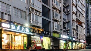 A multi-story building with various shops on the ground floor, featuring large glass windows and balconies. - Ligang Hotel (Chongqing)