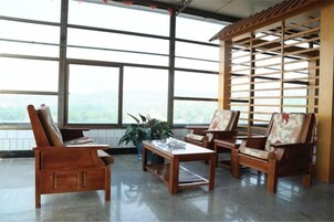 Una habitación con amplias ventanas, muebles de madera y vistas al exterior.