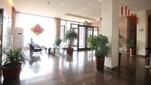 A spacious lobby with a polished floor, potted plants, and a glass door entrance. - Thank You Junyi Inn Huozhou Gulou (Huozhou)