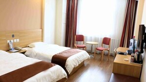 A hotel room with two beds, a small table, a chair, a TV, and a radiator. - Thank You Junyi Inn Huozhou Gulou (Huozhou)