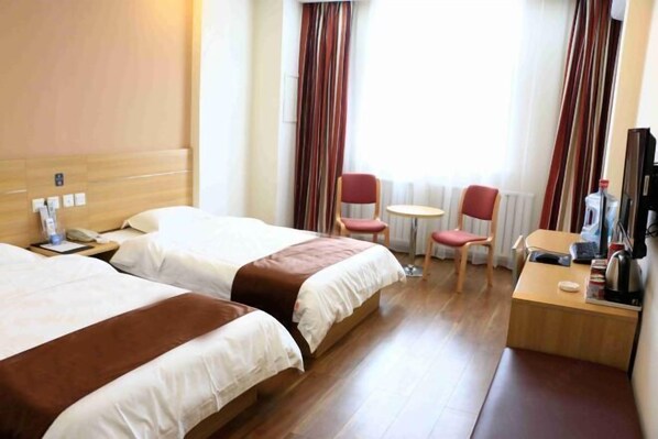 A hotel room with two beds, a small table, a chair, a TV, and a radiator. - Thank You Junyi Inn Huozhou Gulou (Huozhou)