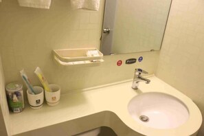 A bathroom with a sink, mirror, and toiletries. - Thank You Junyi Inn Huozhou Gulou (Huozhou)