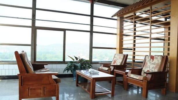 A room with large windows, wooden furniture, and a view of the outdoors. - Thank You Junyi Inn Huozhou Gulou (Huozhou)