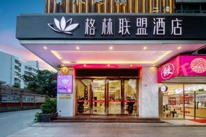 A hotel entrance with a modern design, featuring a prominent sign with Chinese characters and a lotus logo. - Toronto Hotel (Majialong Hotel, Nantou Ancient Town) (Shenzhen)