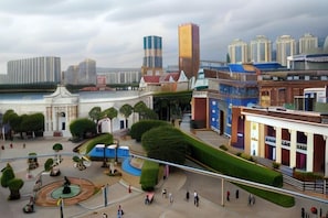 Una amplia plaza con una fuente, rodeada de edificios de variada arquitectura, incluyendo un rascacielos alto.