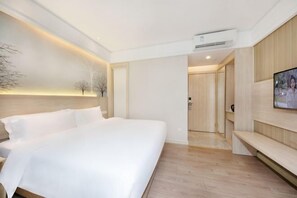 A modern hotel room with a large bed, a flat-screen TV mounted on the wall, and a built-in bench along the wall. - Toronto Hotel (Majialong Hotel, Nantou Ancient Town) (Shenzhen)