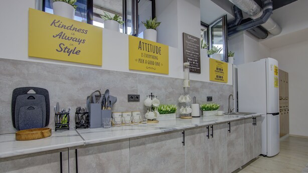 A modern kitchen with a marble countertop, stainless steel appliances, and minimalist decor. - Hostel Pro (Bishkek)
