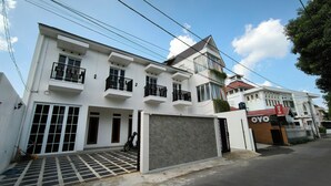 Un immeuble résidentiel moderne à deux étages, doté d’un garage, de plusieurs balcons et d’une entrée sécurisée par un portail.