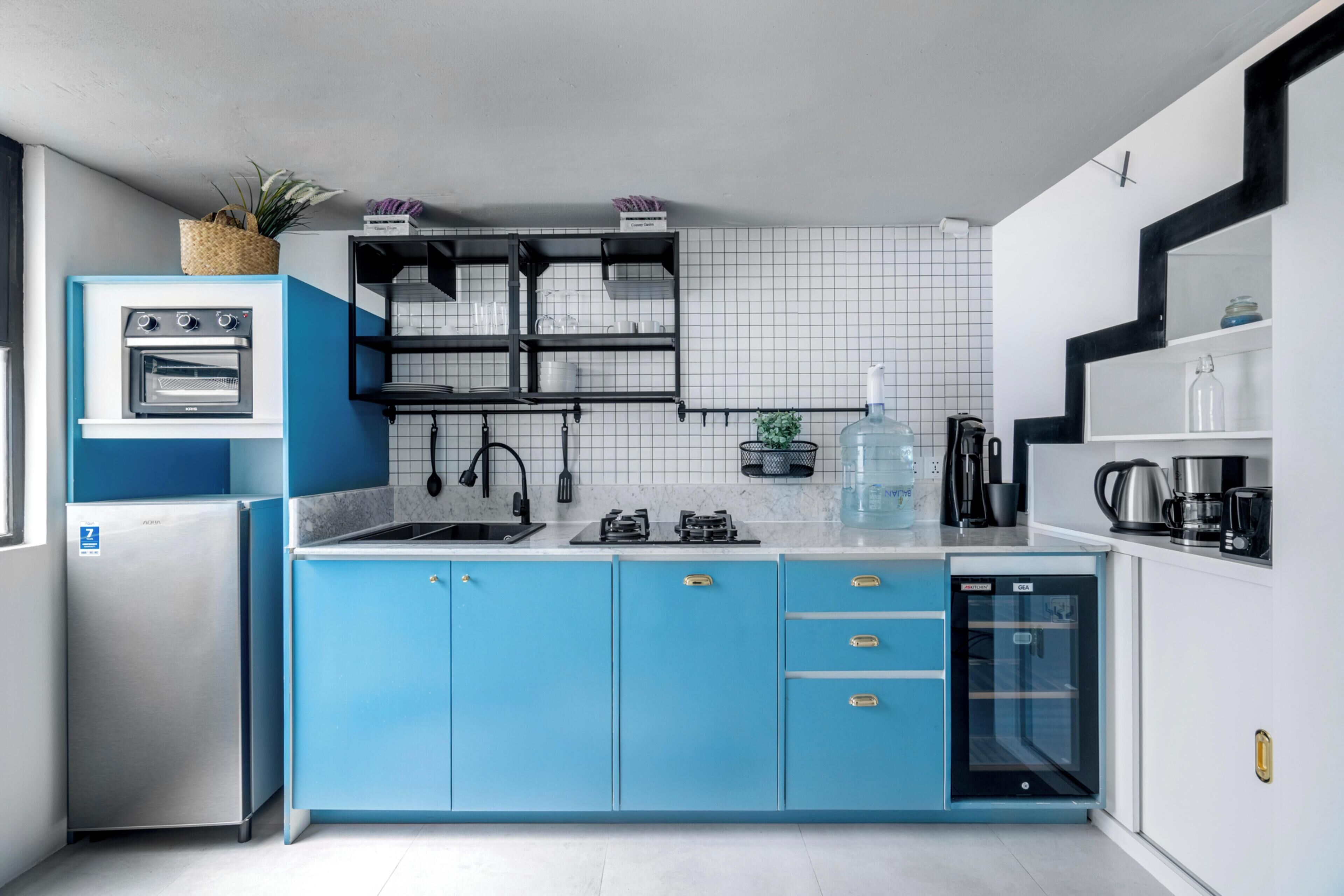 Eine moderne Küche mit blauen Schränken, einem eingebauten Ofen und einem Geschirrspüler.