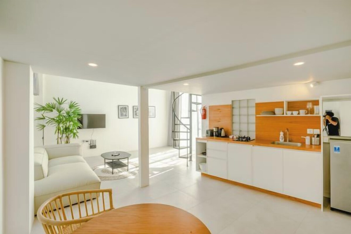 A modern apartment with a kitchen, dining area, and living room.