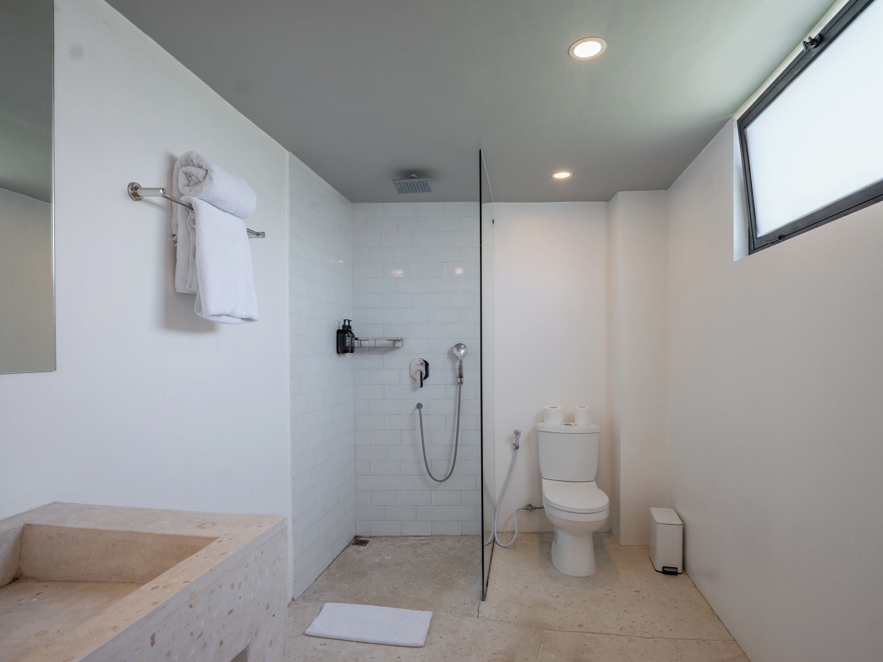 Un baño moderno con ducha, inodoro y lavamanos.