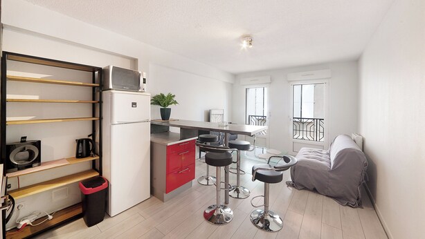 A compact kitchen with a microwave, coffee maker, and a small island with stools. - Le Petit Coin de Lavaur (Lavaur)