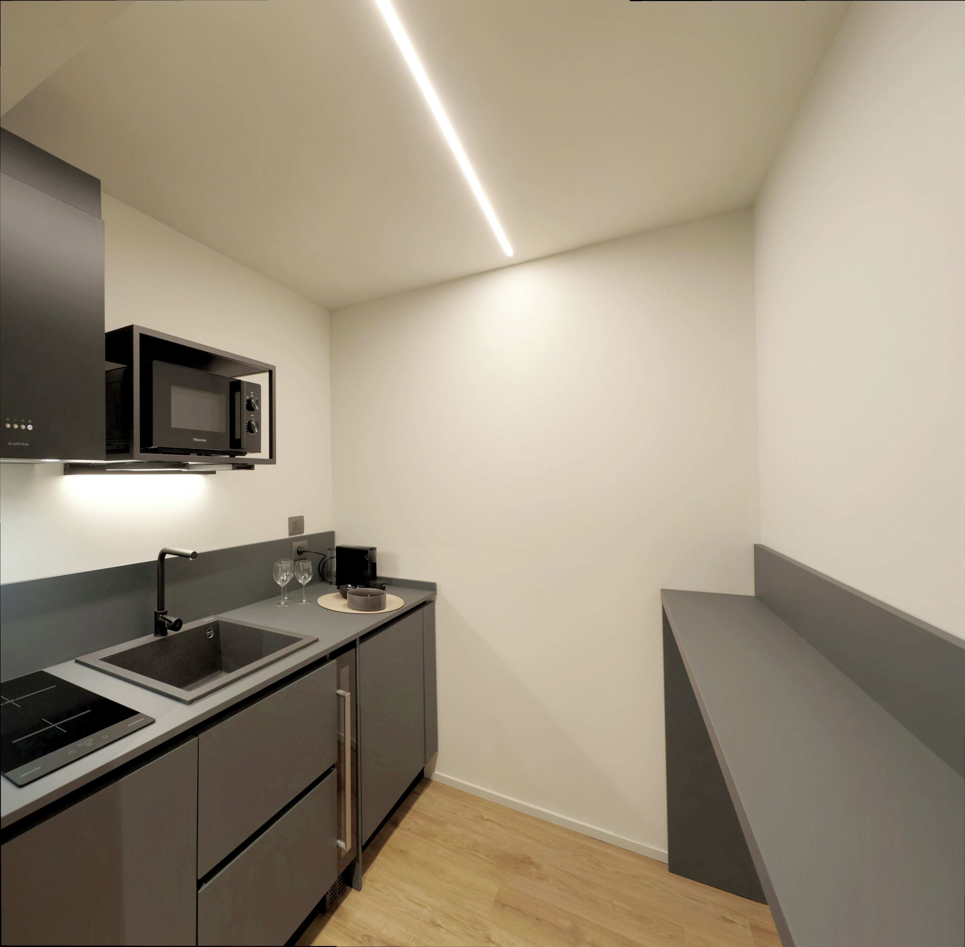 A modern kitchen with a built-in microwave, sink, and stainless steel appliances.
