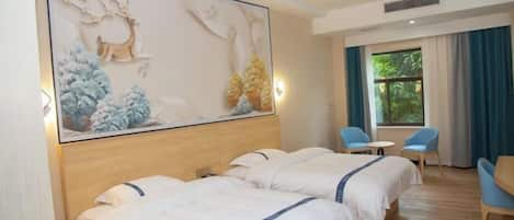 A hotel room with two beds, a large wall mural, a seating area with two chairs and a table, and a window with curtains.