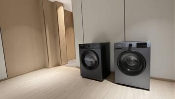 A modern laundry room with two front-loading washing machines.