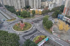 A multi-level urban intersection with a central monument, surrounding greenery, and high-rise buildings. - Janger Hotel (Chongqing Nanchuan branch) (Chongqing)
