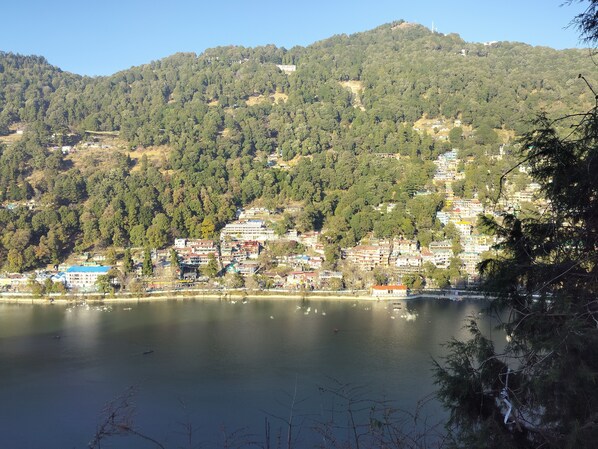 A lakeside view with buildings on a hillside.
