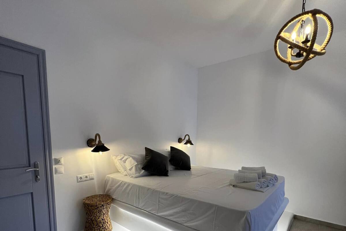 Un dormitorio moderno con cama, lámparas de noche y una lámpara de techo original.