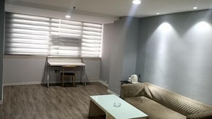 Une pièce comprenant un bureau, une chaise, un canapé et une table basse.