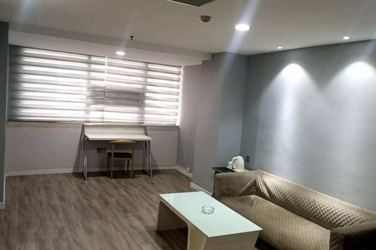 Una habitación con escritorio, silla, sofá y mesa de centro.