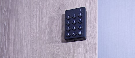 Una puerta moderna con sistema de acceso sin llave, que incluye un teclado numérico y un lector de tarjetas.