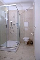 Chuveiro, toalhas de banho, sabonete, shampoo