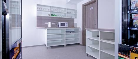 A kitchen with white cabinets, a microwave, and a wooden door.
