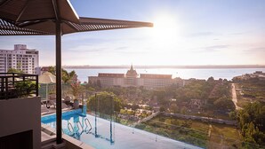 Una piscina infinita en la azotea con vistas a un paisaje urbano y una masa de agua.