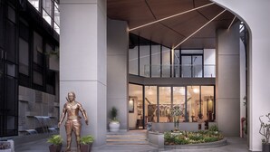 Un edificio moderno con una estatua, plantas de interior y una cascada.