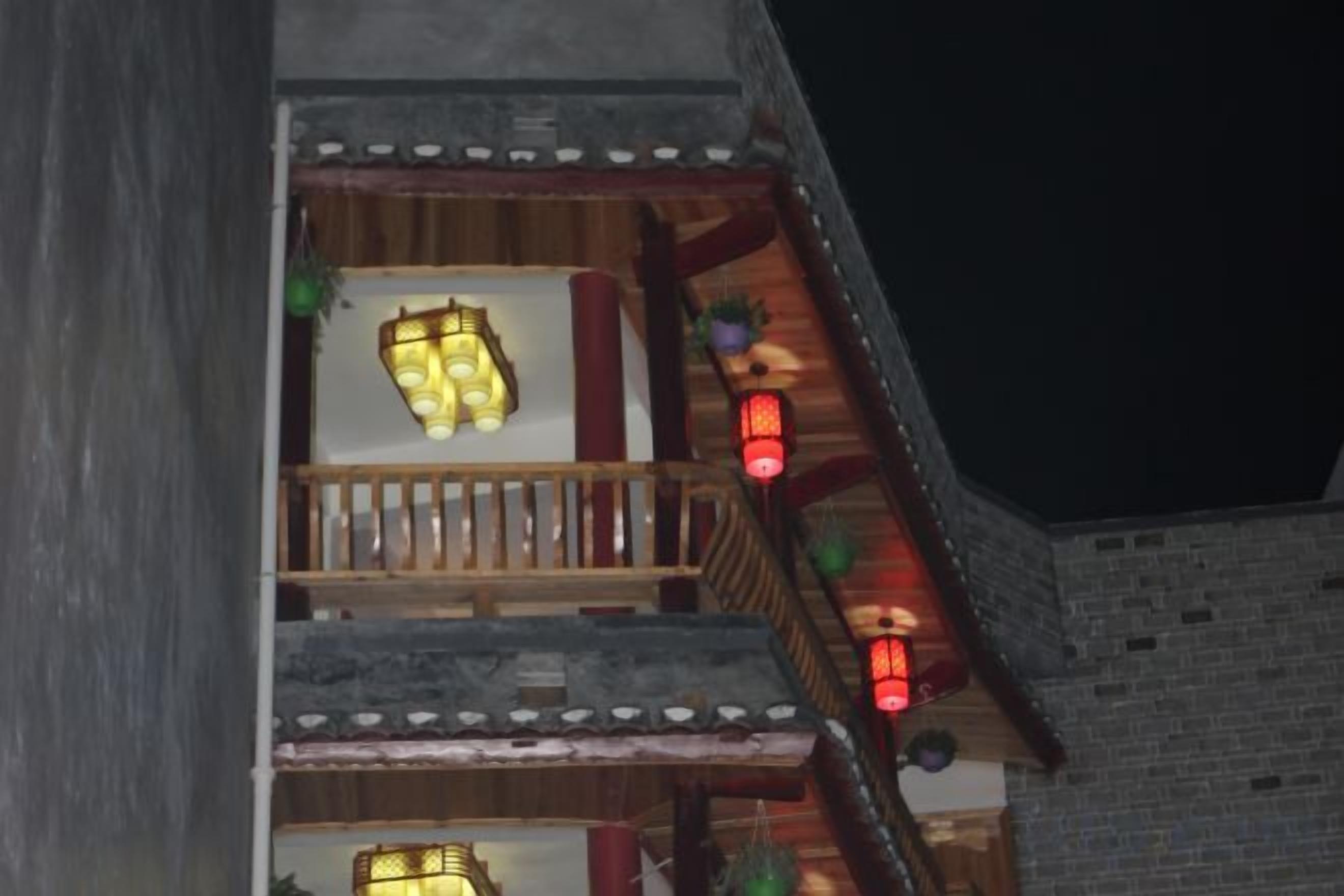 Un edificio de varios pisos con balcones, barandillas de madera y faroles colgantes.