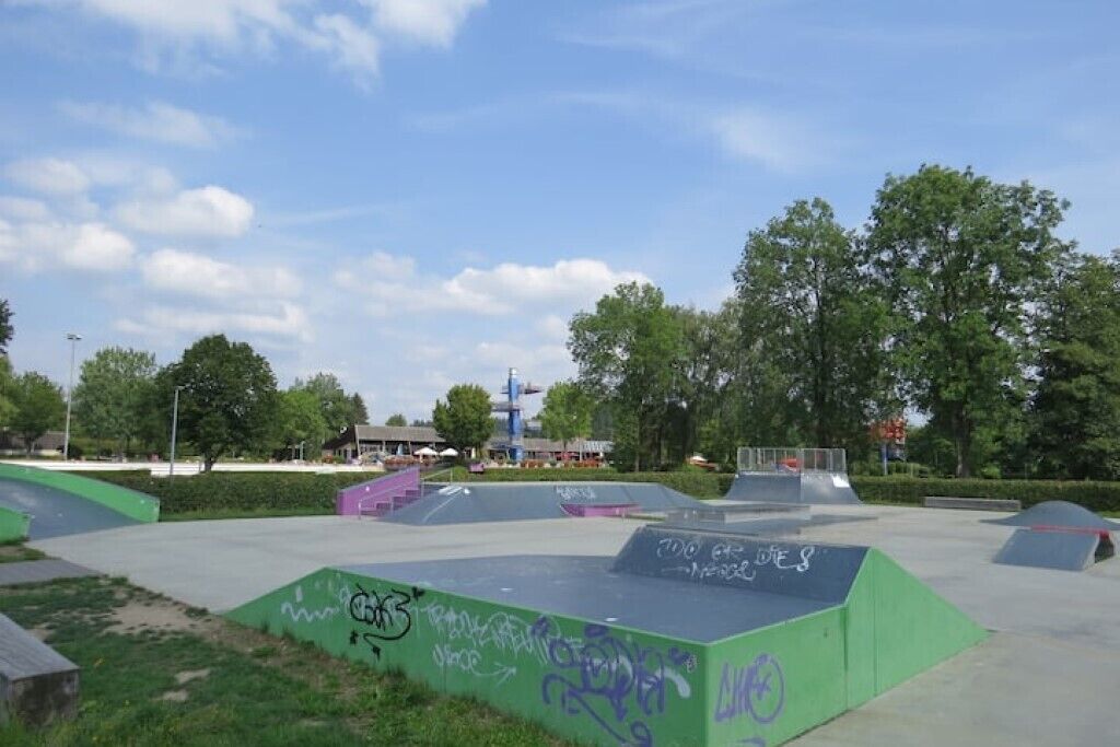 Un parc à skate doté de nombreuses rampes et orné de graffitis.