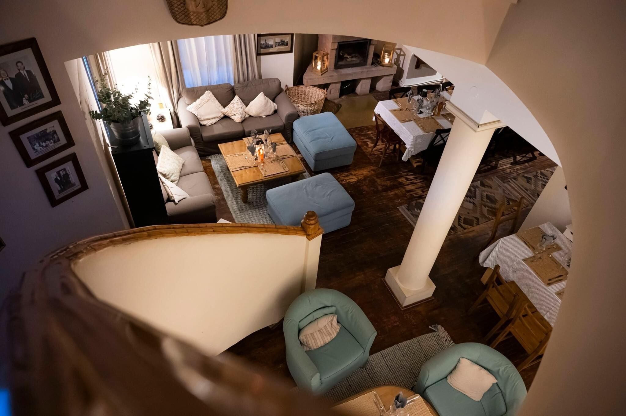 A spacious living area with a sofa set, a dining table, and a fireplace.
