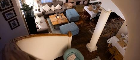 Amplia sala de estar con un conjunto de sofás, una mesa de comedor y una chimenea.