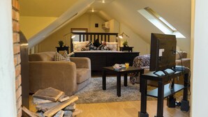 A cozy loft bedroom with a bed, a desk, and a TV. - Ratiu House (Turda)