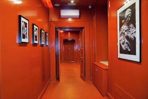 Stunning corridor with framed photographs and a large picture, leading to a door.