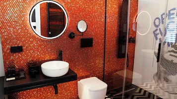 A bathroom with a circular mirror, a white sink, and a toilet.