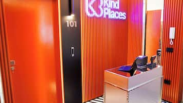 A modern elevator with a neon sign reading "Kind Places" and a number "101" on the wall.