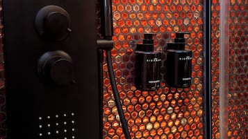 A bathroom with a hexagonal tile backsplash and two bottles of hair products.
