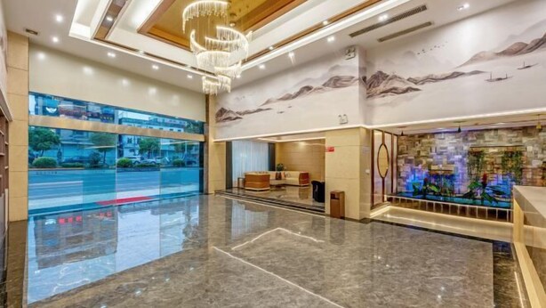 A spacious lobby with a marble floor, a chandelier, and a reception area with a decorative wall. - Cornwall Hotel Chaozhou (Chaozhou)