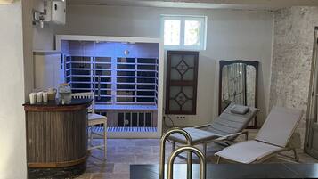 Zona de spa con piscina, mostrador de recepción y área de descanso con vistas a la piscina.
