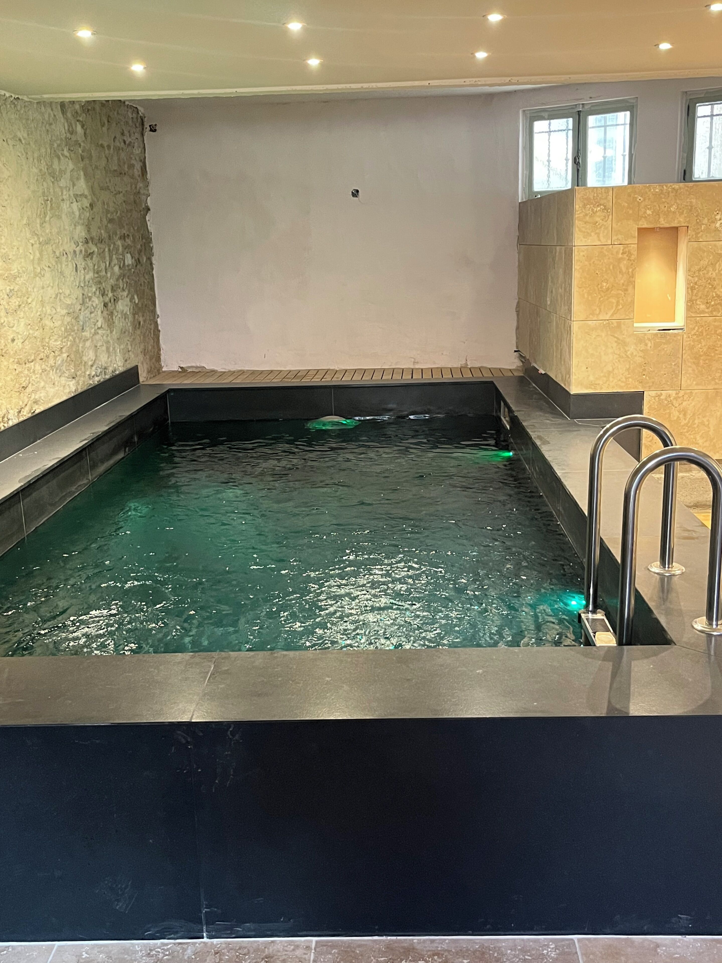 Una piscina techada, sillones reclinables de piscina