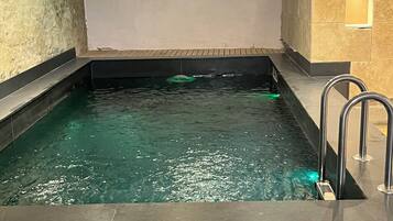 Una piscina techada, sillones reclinables de piscina
